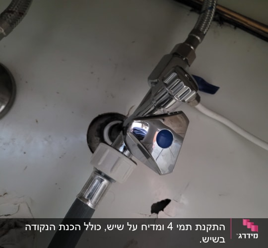 ברז מתכת עם צינור גומי מתחת לכיור